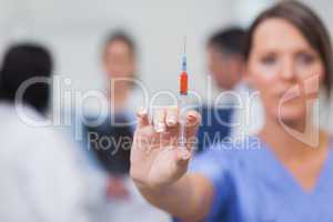 Nurse showing syringe