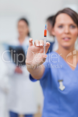 Nurse showing syringe in her hand