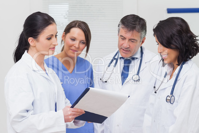 Nurse and doctors looking at clipboard Nurse and doctors looking at clipboard