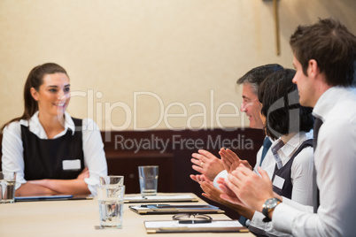 Business people clapping colleague