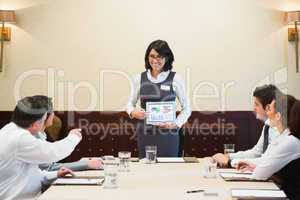 Smiling woman using tablet in presentation