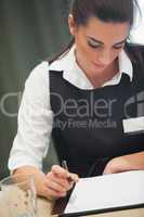 Businesswoman looking down at notepad