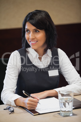 Smiling businesswoman taking notes