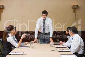 Businessman standing at head of table