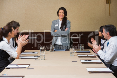 Businesswoman being applauded by peers
