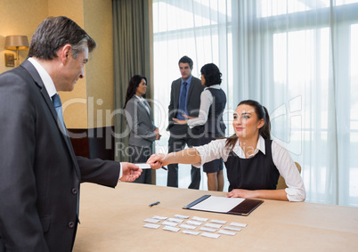 Woman handing name tag to businessman
