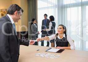 Woman handing name tag to businessman