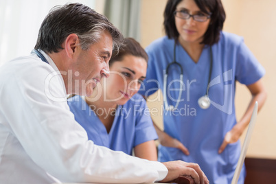 Doctor and two nurses looking at laptop