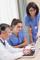 Nurses and doctor looking at laptop