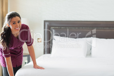 Hotel maid making up the bed