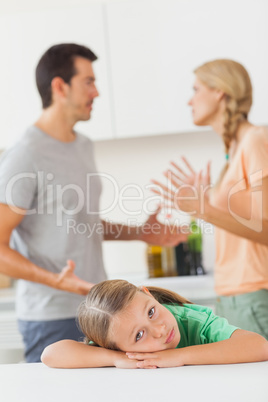 Parents arguing behind a sad girl