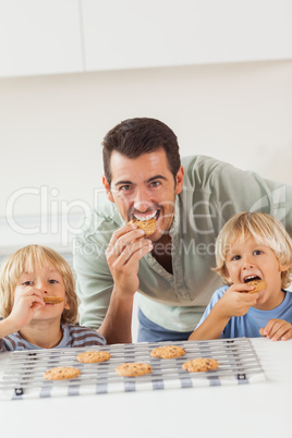 Father and his sons eating cookies
