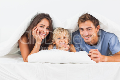 Family smiling under the duvet