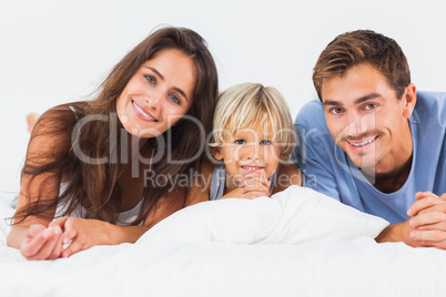 Family lying on a bed together