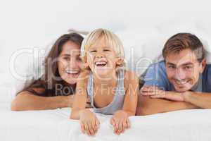 Happy family lying on a bed together