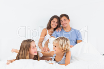 Smiling children lying on the bed