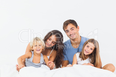 Happy family posing on the bed