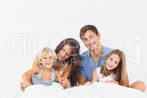 Happy family posing on the bed