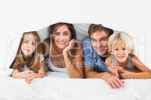 Happy family in the duvet smiling