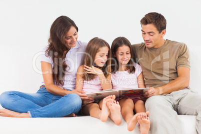 Family reading a story on a sofa