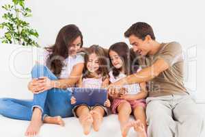 Smiling family using a digital tablet