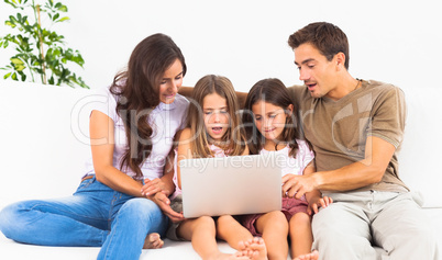 Family posing on a sofa with the laptop