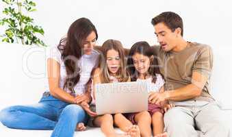 Family posing on a sofa with the laptop