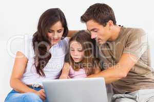 Family sitting on a sofa with the laptop