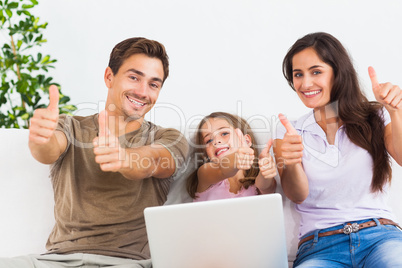 Family giving thumbs up with the laptop