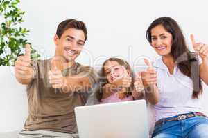 Family giving thumbs up with the laptop