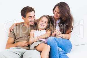 Smiling family playing together on a sofa