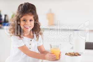 Cute girl smiling with her orange juice in hand