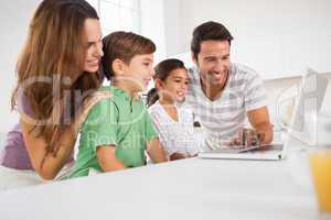 Happy family using a laptop