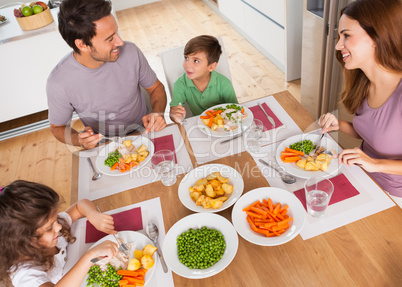 Family smiling around a healthy meal