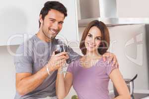Couple toasting and looking at camera