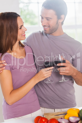 Lovers toasting standing with a glass of wine