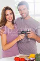 Lovers toasting with a glass of wine and looking camera