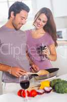 Couple preparing food and drinking