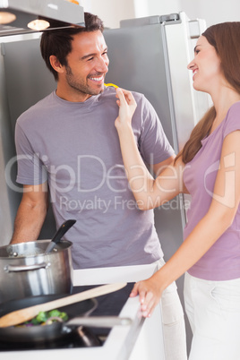 Woman feeding man with a yellow pepper