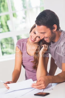 Smiling lovers in front of invoices