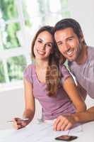 Couple smiling at the camera with invoices
