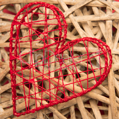 Red heart shaped ornamental box on wicker