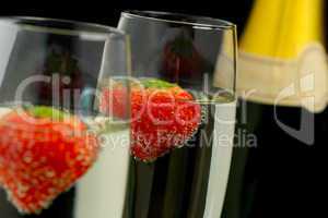Strawberries floating in two champagne flutes