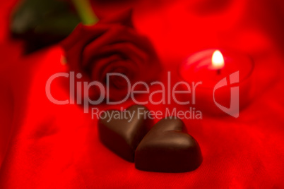 Red rose candle and chocolate hearts