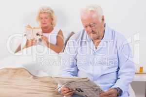 Old couple reading on the bed