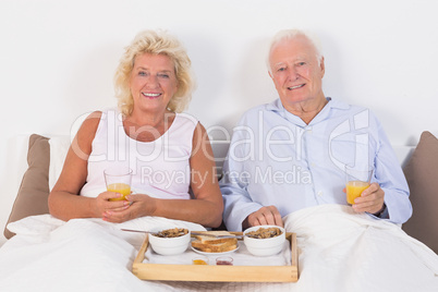 Aged couple eating breakfast