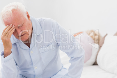 Old man suffering while woman sleeping
