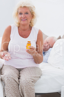 Old woman with an opened pill bottle