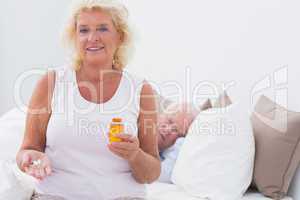 Old woman with the opened pill bottle