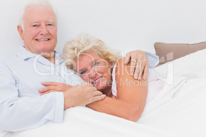 Cheerful couple lying on the bed